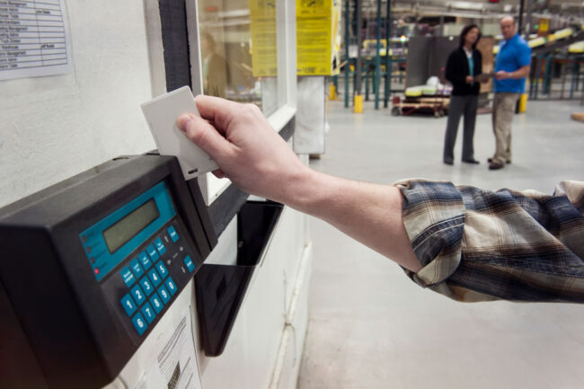 person-clocking-in Person's hand clocking in from a Biometric time clock.