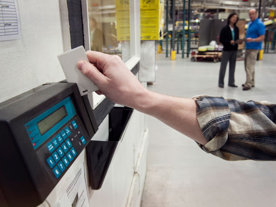 person-clocking-in Person's hand clocking in from a Biometric time clock.